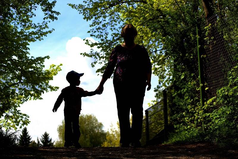 En förälder och ett barn tar en promenad