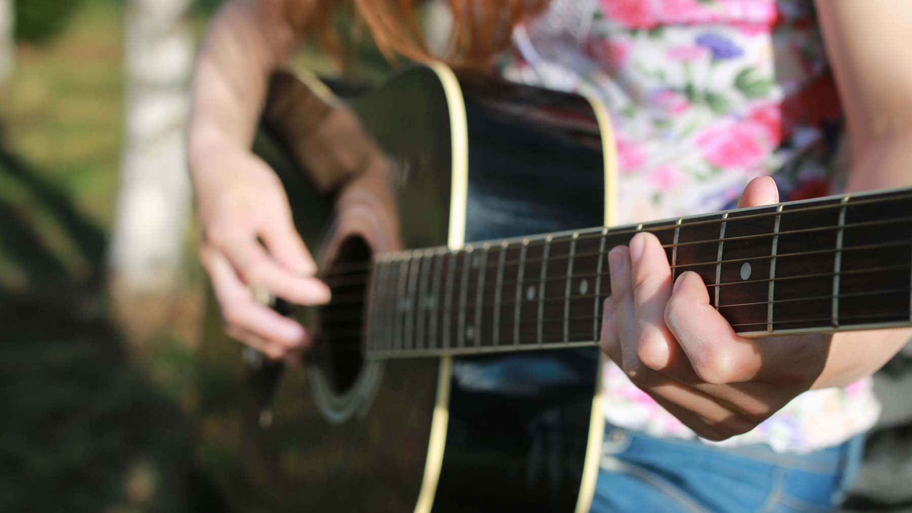 Flicka som spelar gitarr.