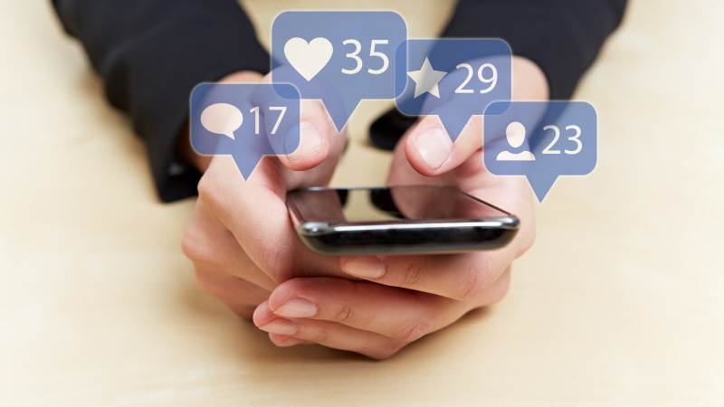 Hand som håller i en iphone med sociala medier