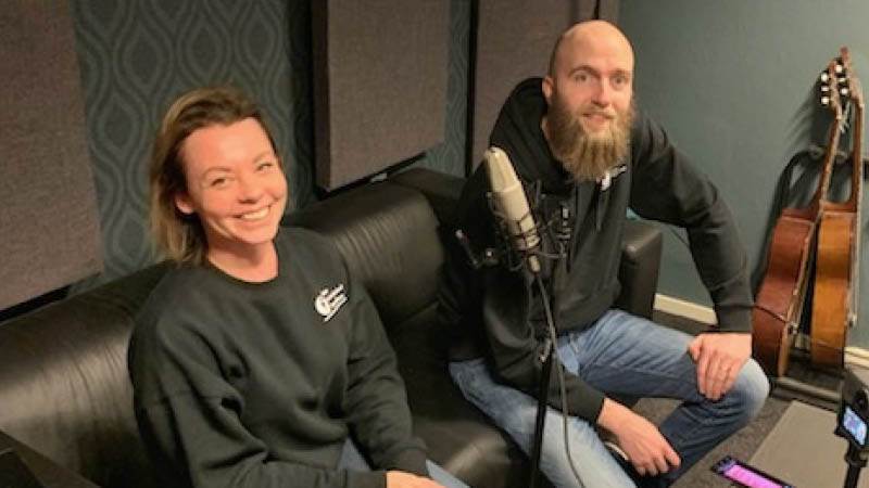 Emmelie Andreasson och Fredrik Torin på studiebesök i Vimmerby. Emmelie Andreasson och Fredrik Torin sitter i en soffa och ler mot kamerian.