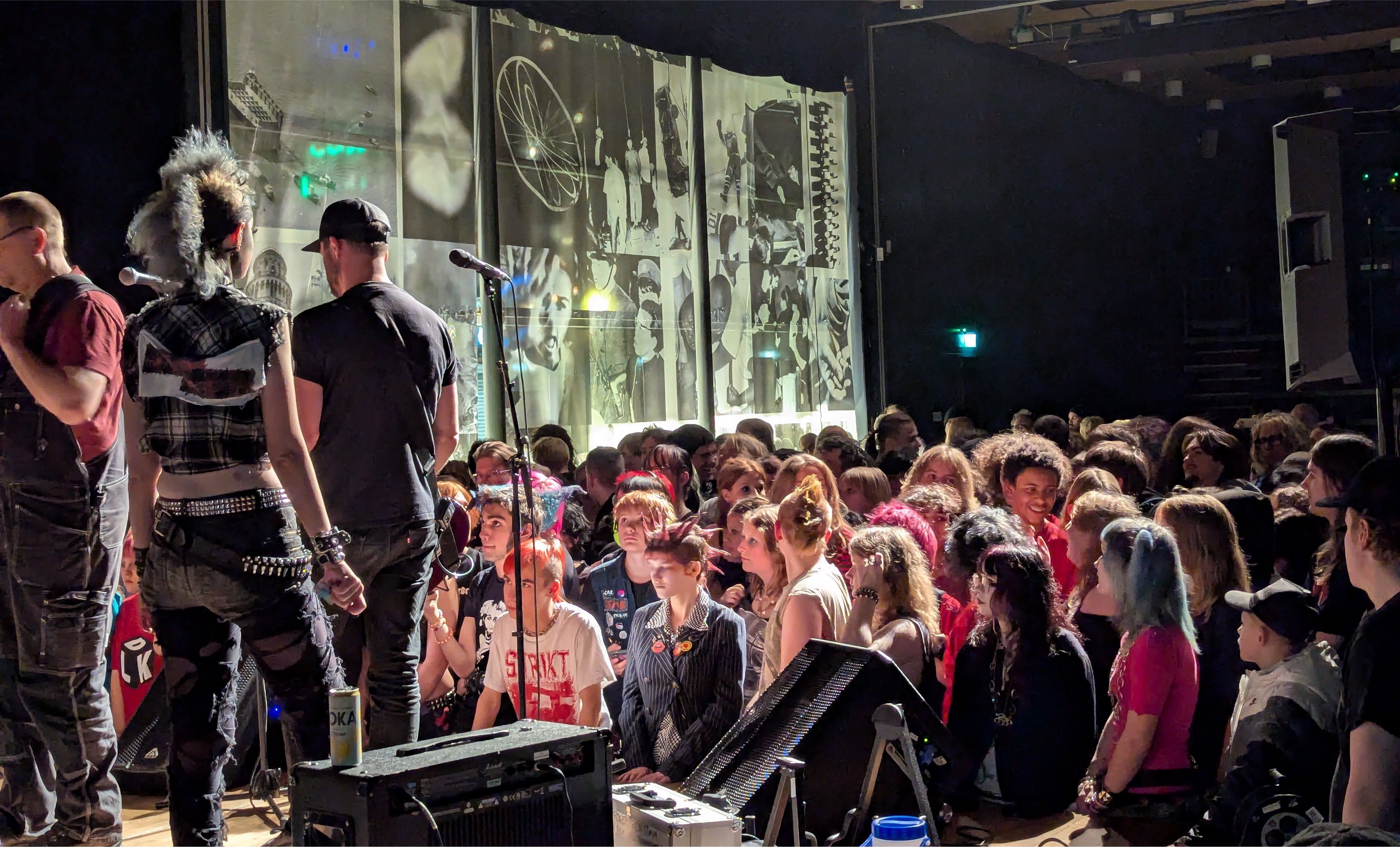 Publik framför en scen under en konsert i en mörk konsertlokal.