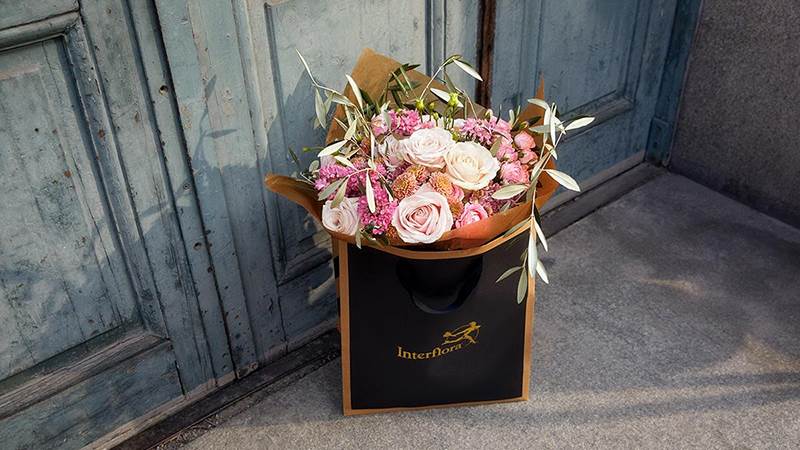 Blommor i påse framför dörr