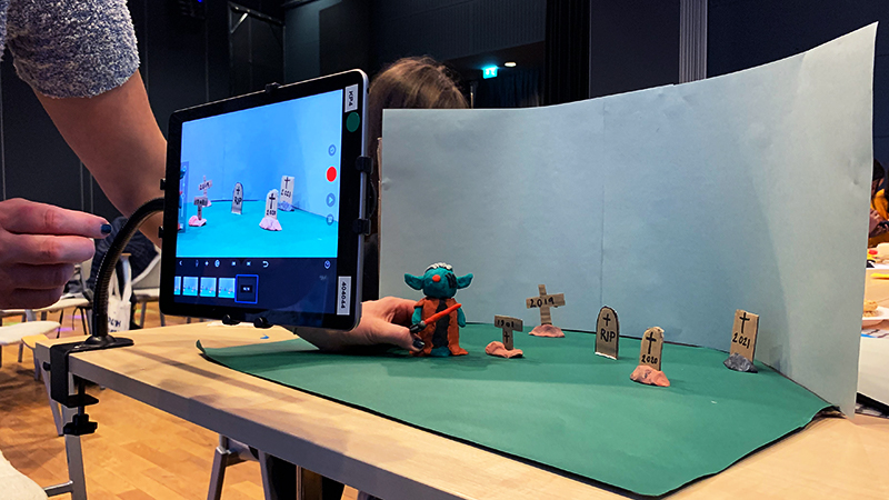 Ett monster som går bland gravstenar vid en green screen