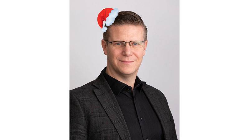 Henrik Lindh, utbildningsdirektör, önskar God Jul och Gott Nytt År. Henrik Lindh, utbildningsdirektör med liten toppluva på huvudet.