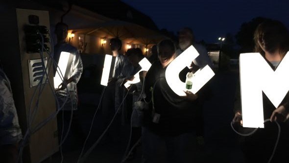 Personer håller upp lysande bokstäver, konstverket Litiummonumentet