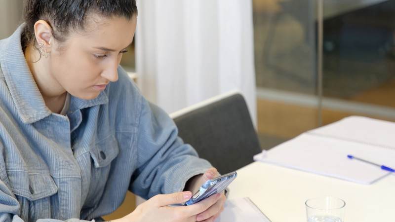 Dags för digital gymnasiemässa.  Gymnasieelev läser på sin mobil.