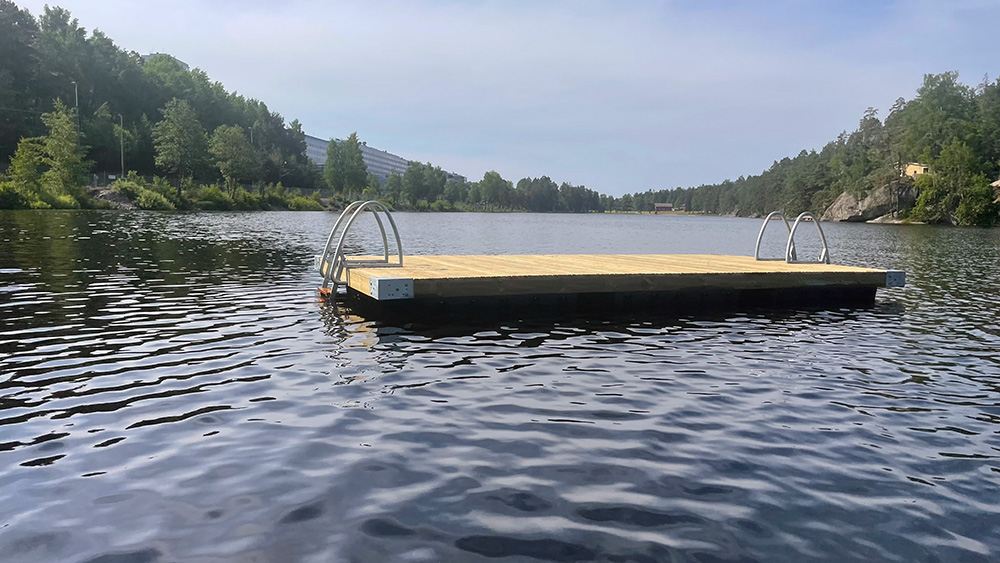 Träbrygga som flyter i sjö.