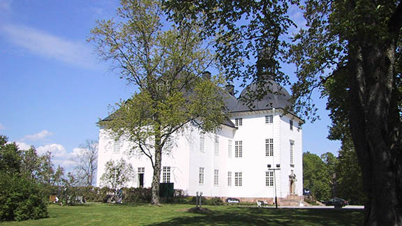 Stort, vitt slott med grönområde runt.