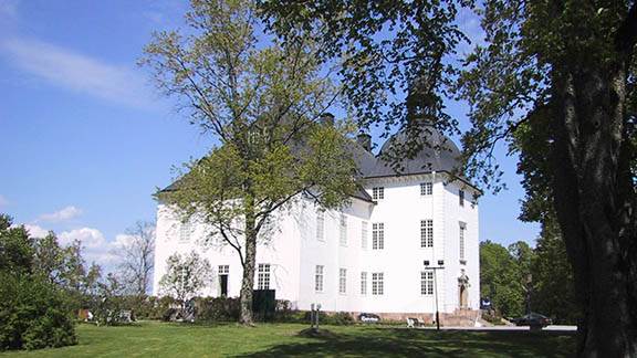 Stort, vitt slott med grönområde runt.