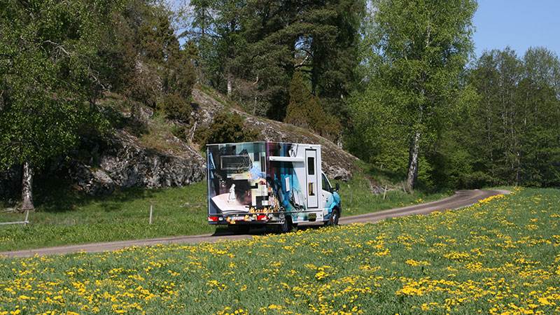 Bokbussen åker på en landsväg en solig sommardag