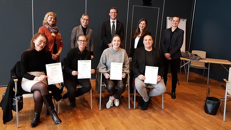 Grupp människor sitter på rad.