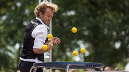en man som jonglerar med bollar på studsmatta
