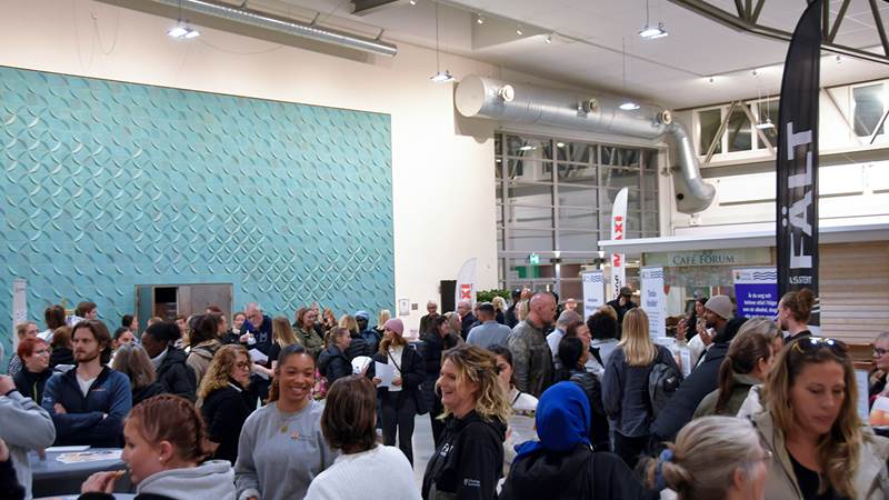 Mingelbild från kvällen där besökare och utställare samlas och samtalar vid olika informationsbord för de olika verksamheterna.