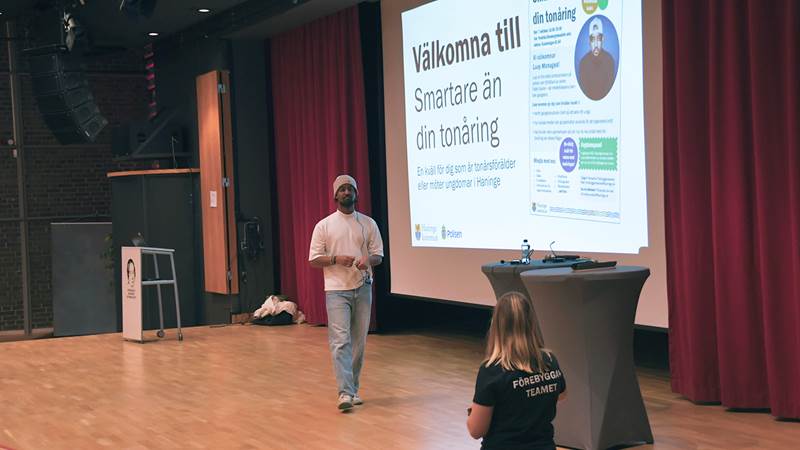 Föreläsaren är på scen och samtalar med en person från Förebyggarteamet.