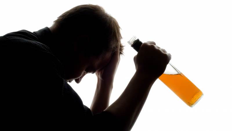Alkohol, droger och spel En man sitter med en öppnad flaska vin.