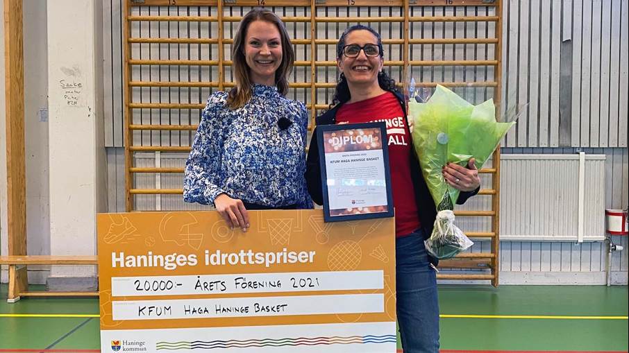 Nicole Forslund och en representant från KFUM Haga Haninge håller i en stor vinnarcheck.