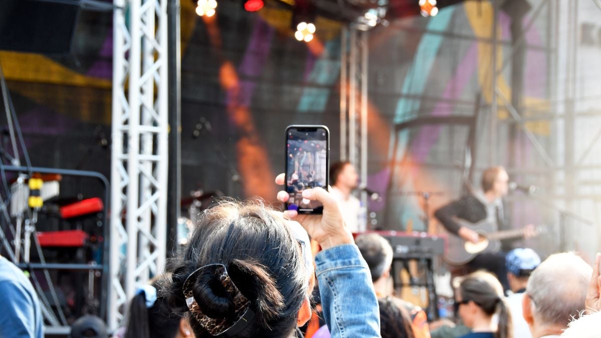 Besökare vid en scen under Haningedagen. En person filmar uppträdandet med en mobiltelefon.