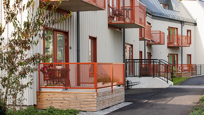 R&#246;d balkong och uteplats p&#229; ett gr&#229;tt tr&#228;hus