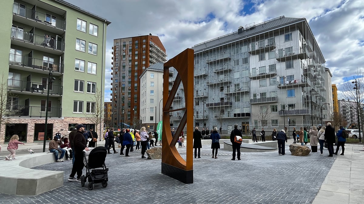 ett öppet torg med konstverk i form av skulpturer samt människor s