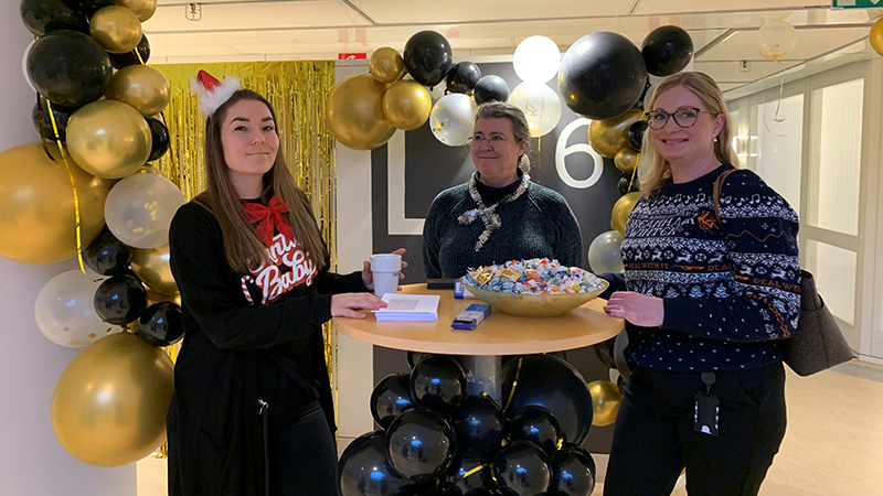 Medarbetare med ballonger bakom