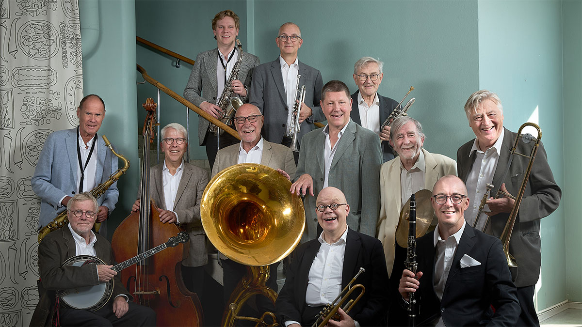 Grupporträtt av tolv musiker med instrument.