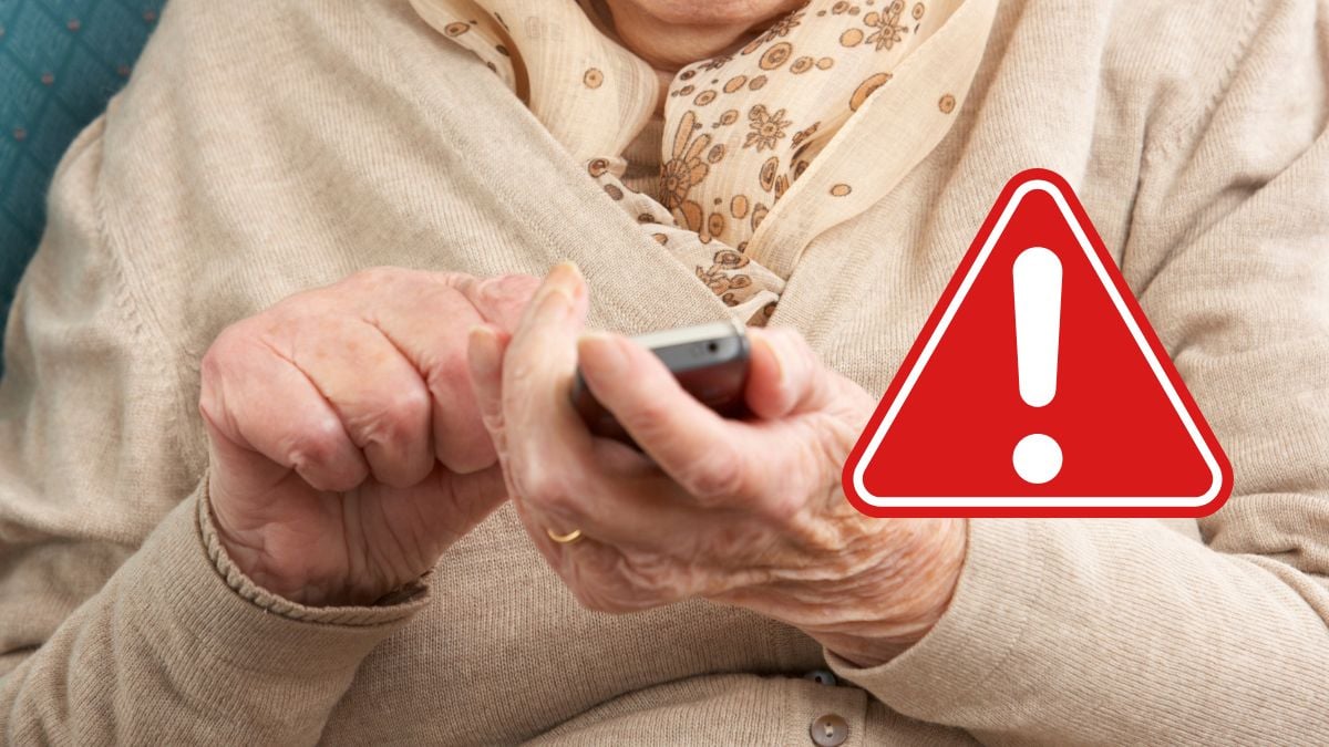 Närbild på en person som läser ett sms i en mobiltelefon. En röd varningssymbol är tillagd i bilden.