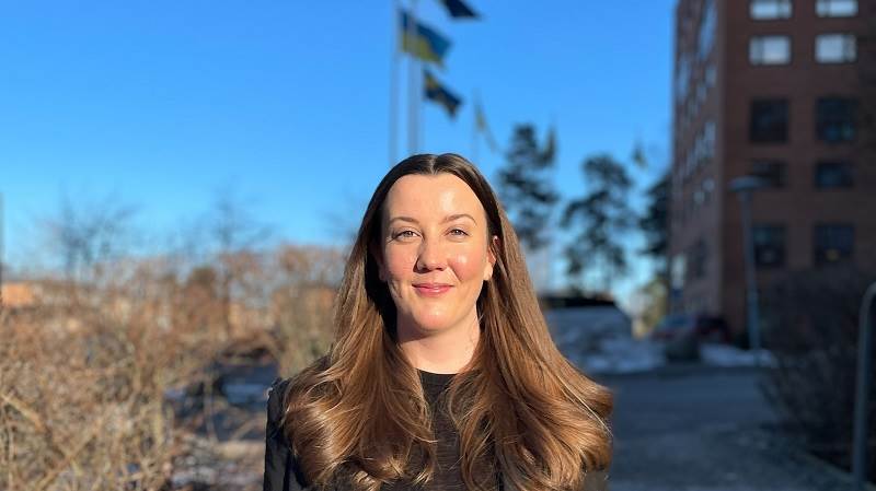 Fredrika Forslund, verksamhetsstrateg. Kvinna framför hus.