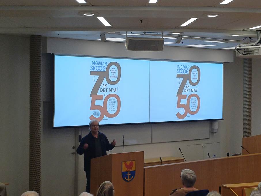 Seniorforskaren Ingmar Skoog föreläste på temat "70 är det nya 50" och om att bryta ofrivillig ensamhet. Bild på en man som står på en scen framför publik och pratar. I bakgrunden syns texten "70 är det nya 50"