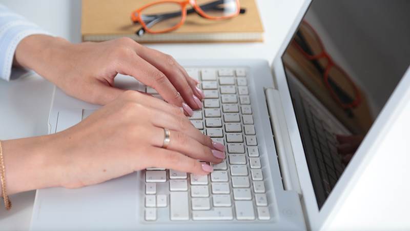 Kvinna skriver på laptop