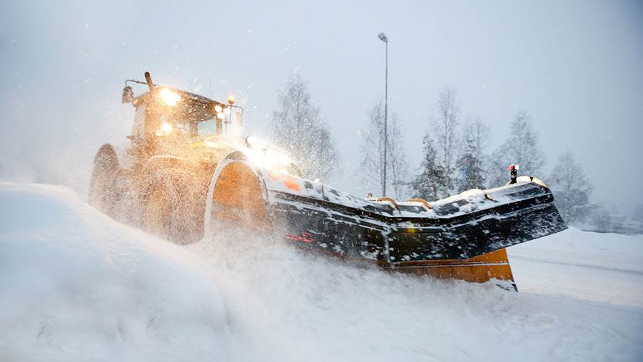 Snöplog kör i snöoväder.