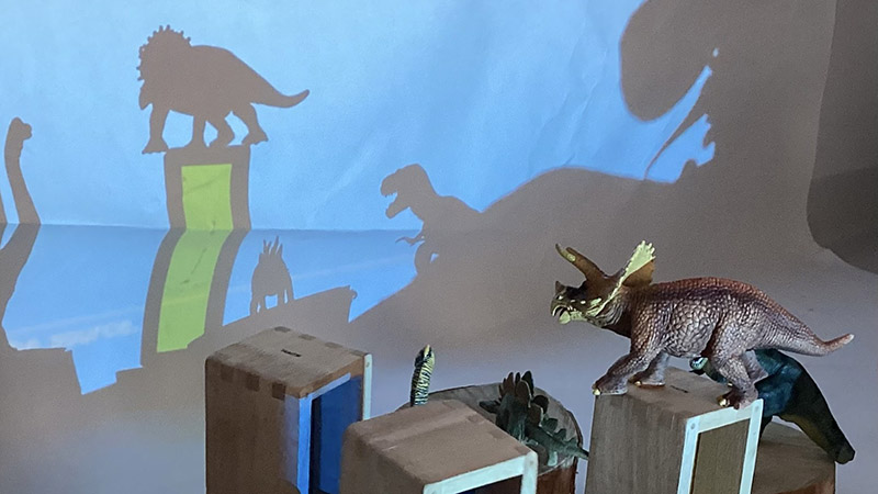 Skuggor bildas av leksaksdinosaurier.
