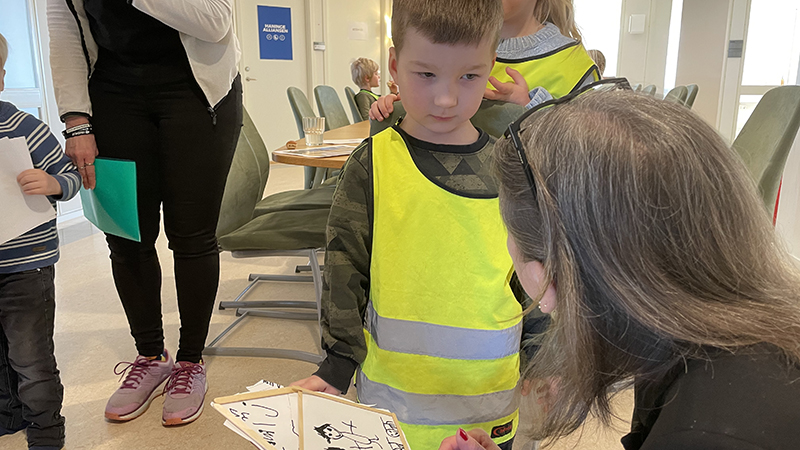 Barn visar teckning för en pedagog