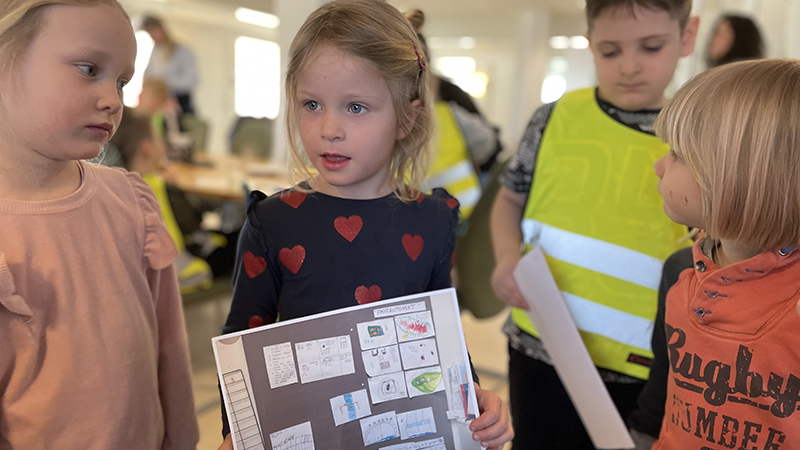 Fyra förskolebarn visar upp teckningar