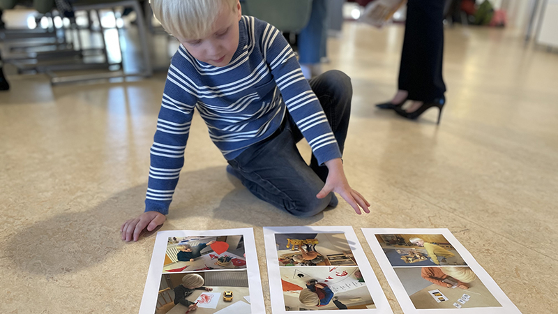 Pojke sitter på golvet och tittar på bilder