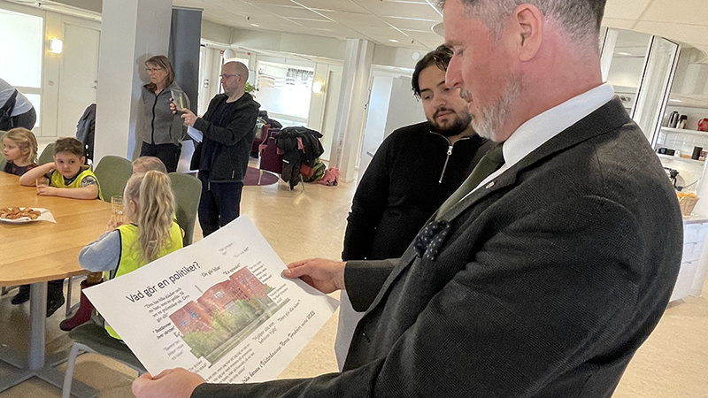 Kommunstyselsens ordförande Sven Gustavsson tittar på en planch med texten "Vad gör en politiker?"