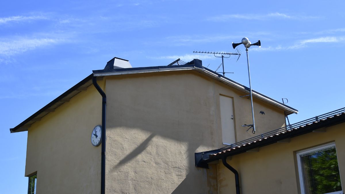 monterad på fasaden av en byggnad, sedd från marknivå mot himmel.