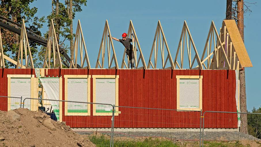 Rött hus med takstolar synliga