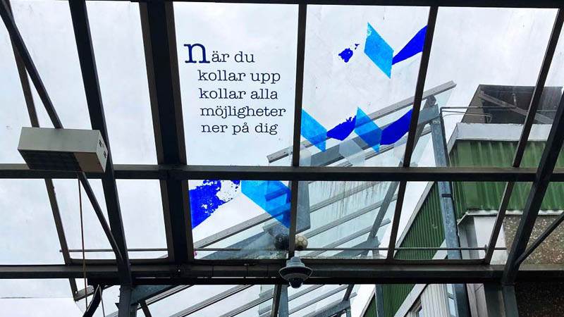 Texten "När du tittar upp tittar alla möjligheter ner på dig" i glastaket i Jordbro centrum.