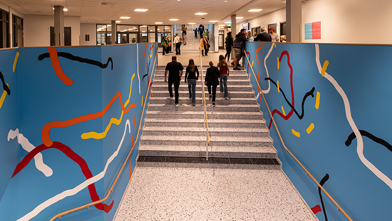 Besökare går uppför en stenstrappa  inomhus.