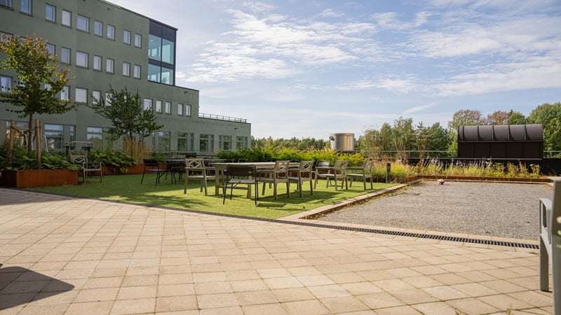 Grönskande terrass med plats för sittgrupp och boulebana