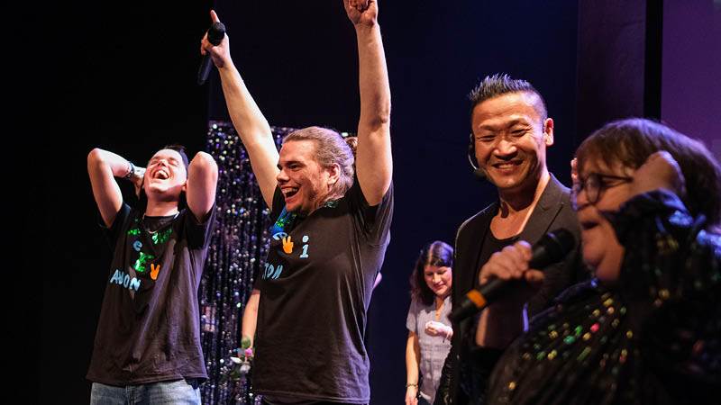 Anton Wallman och Niklas Martinsson vann Haninges delfinal i Funkisfestivalen 2021. Vem blir vinnaren i år? Anton Wallman och Niklas Martinsson jublar med armarna i luften. Konferenciern Mårten Nylén står bredvid och ser glad ut.