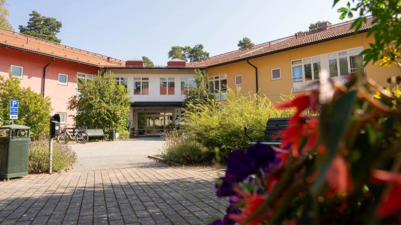 Johanneslund är ett särskilt boende för äldre, för äldre som behöver omsorg dygnet runt. Entré till hus med två våningar och lummig utomhusmiljö.