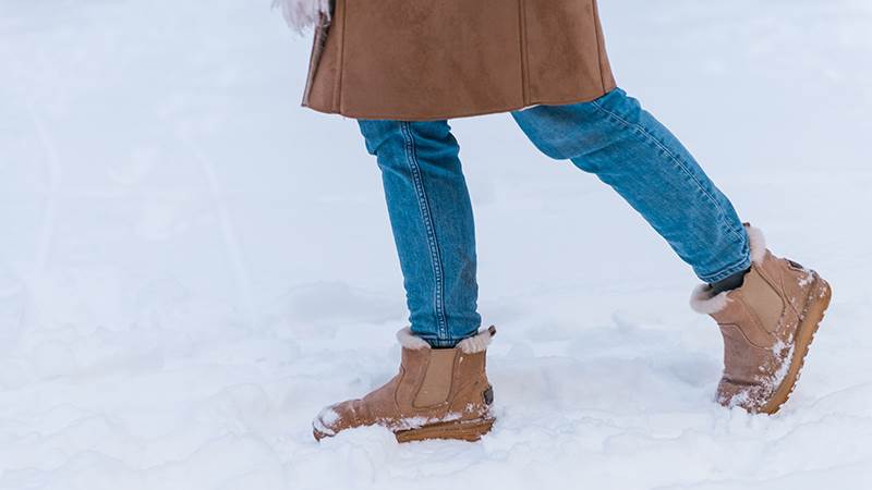 Kvinnas ben och fötter i snömodd