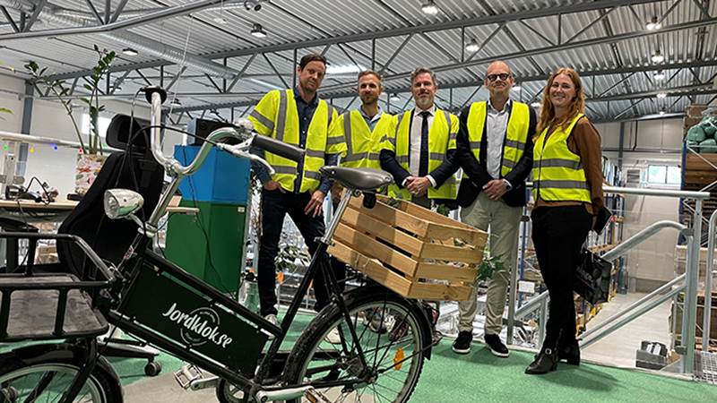 Representanter från kommunens näringslivsenhet, kommunstyrelsens ordförande, personal från Jordklok ståendes bakom en cykel med företagets logotyp på.
