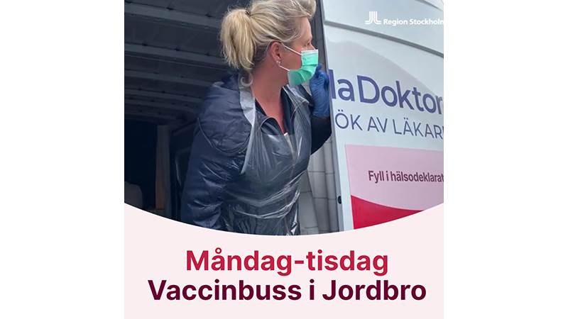 Kvinna med munskydd tittar ut ur en vaccinationsbuss