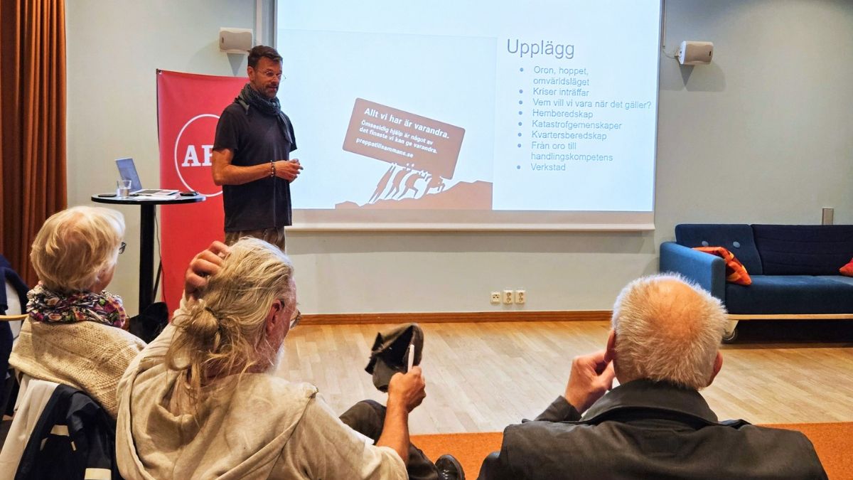 Föreläsare står framför en presentationsbild och berättar om kvartersberedskap för en sittande publik.