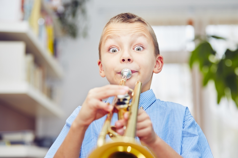 En ung kille som spelar trumpet