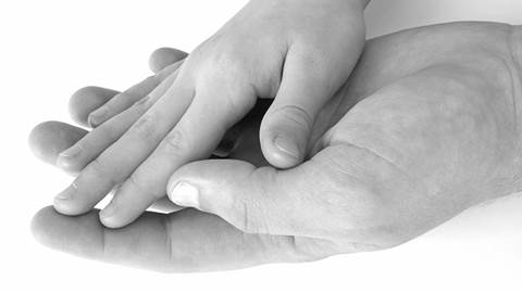 En liten hand och en stor hand håller i varandra