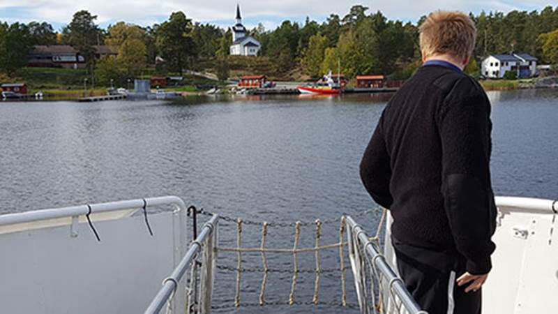 Bokbåten på väg in mot Ornö. En man på en båt på väg mot land