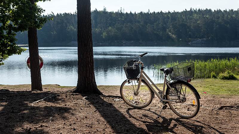 Kanske vill du använda din förmånscykel och cykla till fina Ramsjön? Cykel parkerad på strand vid Ramsjön.